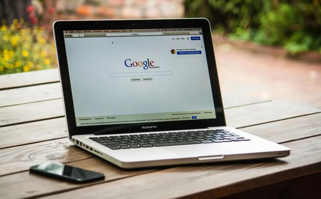 Laptop exibindo a página inicial do Google, com uma busca relacionada a Como fazer ADS no Mercado Livre, demonstrando estratégias de publicidade online
